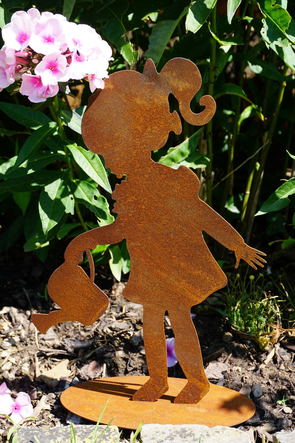 Girl watering flowers made of rusted metal