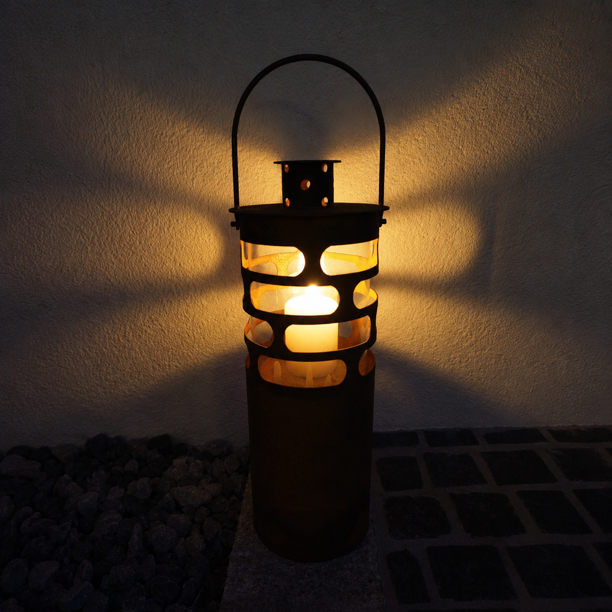 Edelrost Laterne Moderna im 3er-Set auf Terrasse mit Kerzen und Lichterkette im Hintergrund


