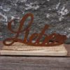 Schriftzug "LIEBE" aus Metall mit Edelrost-Patina auf einem Holzsockel